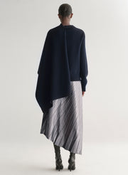 woman wearing silver one shoulder top and matching midi skirt