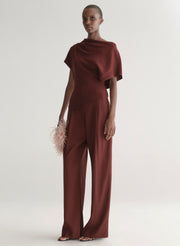 woman wearing maroon draped top with matching wide leg pants