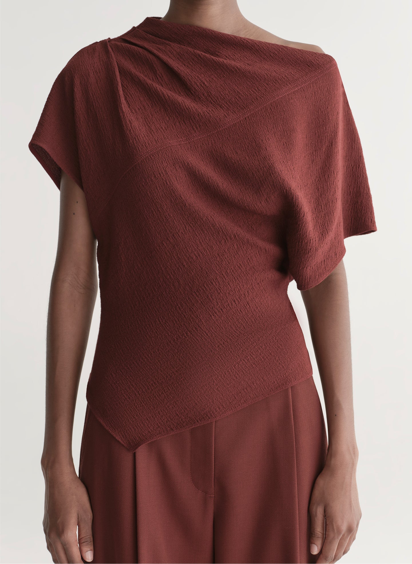 woman wearing maroon draped top with matching wide leg pants