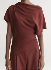 woman wearing maroon draped top with matching wide leg pants