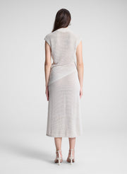 woman wearing cream asymmetric knit top and matching midi skirt