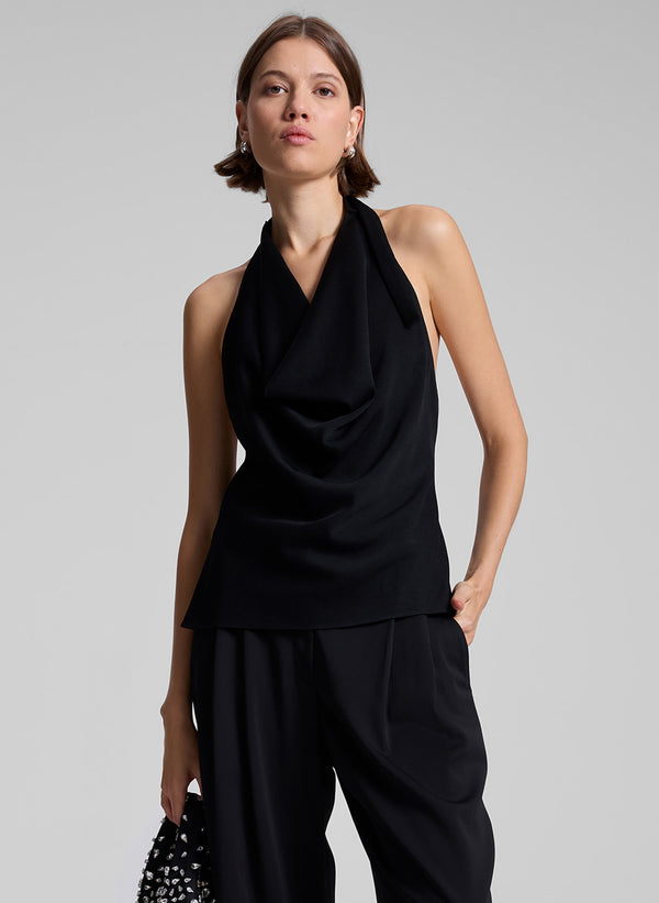 woman wearing black cowl neck sleeveless top and black pants