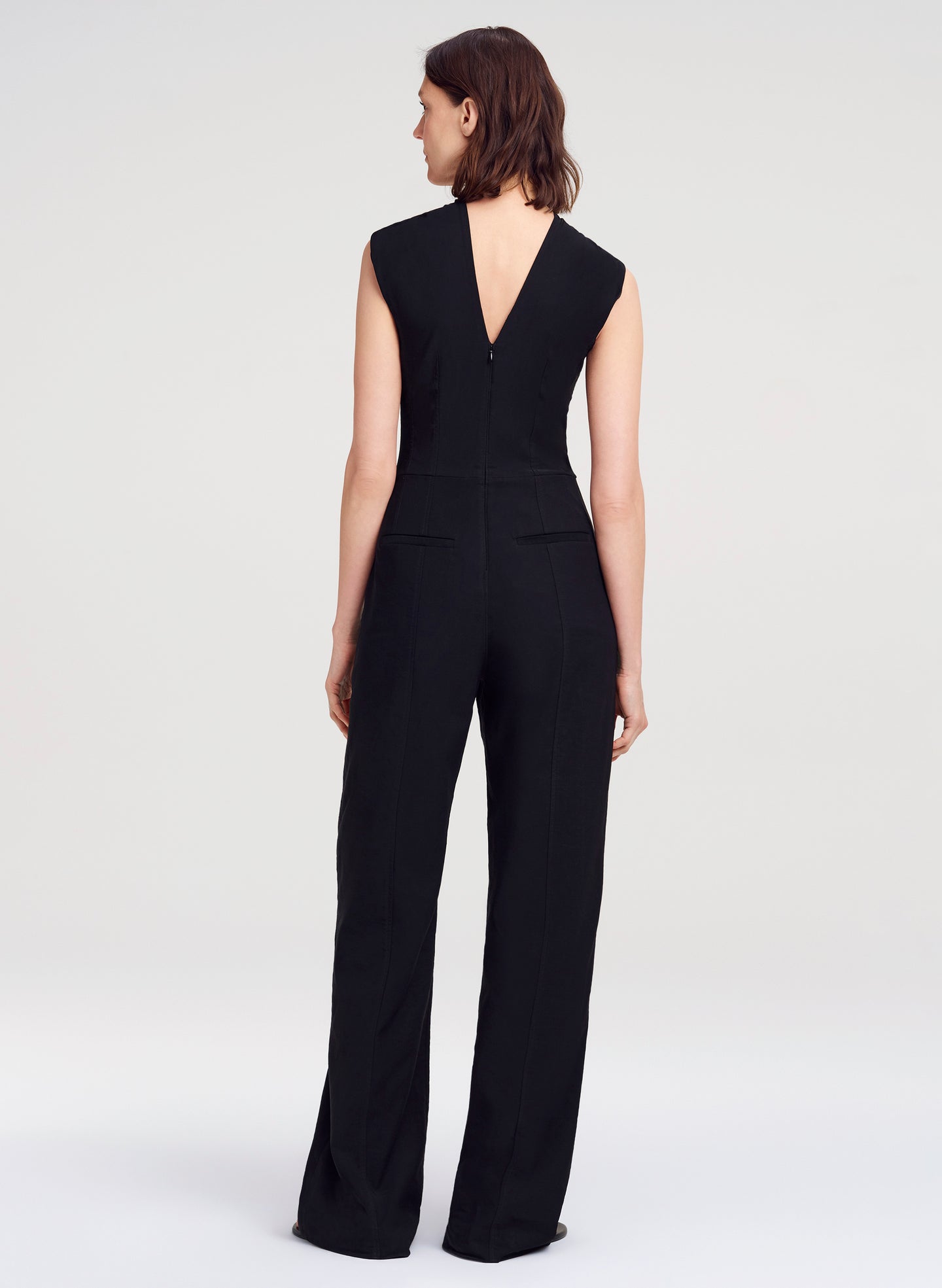 Woman wearing a black jumpsuit on a white background