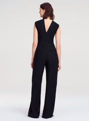 Woman wearing a black jumpsuit on a white background