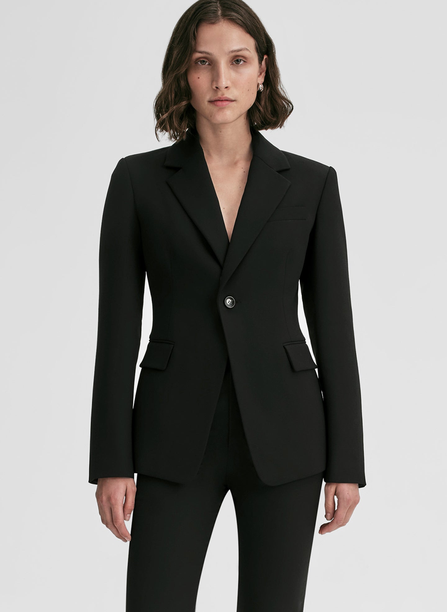 Person wearing a black suit on a white background