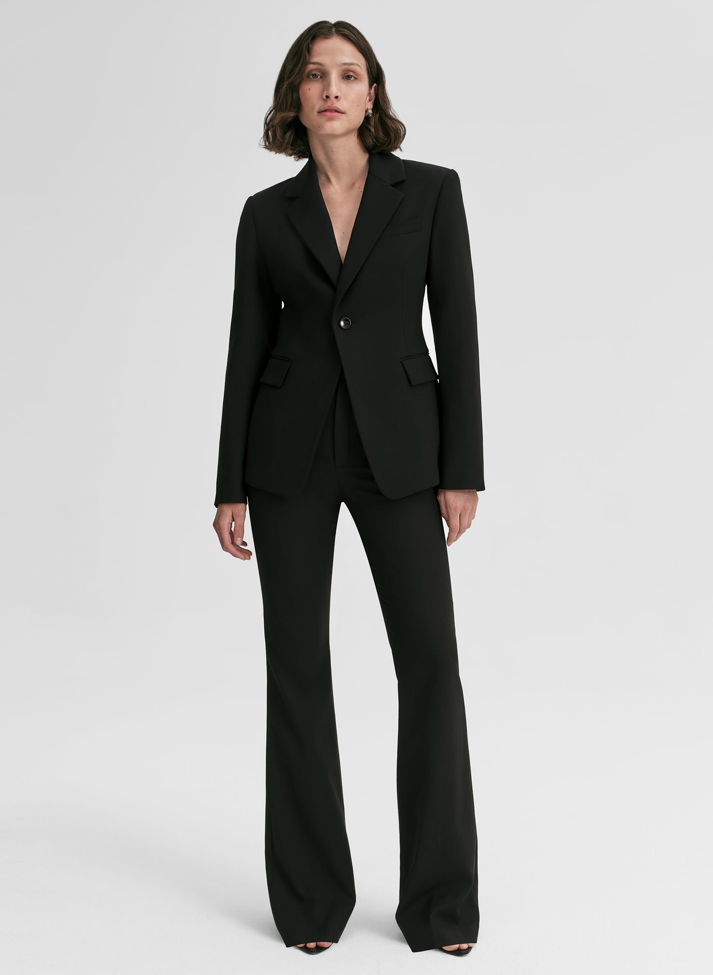Woman wearing a black suit on a white background