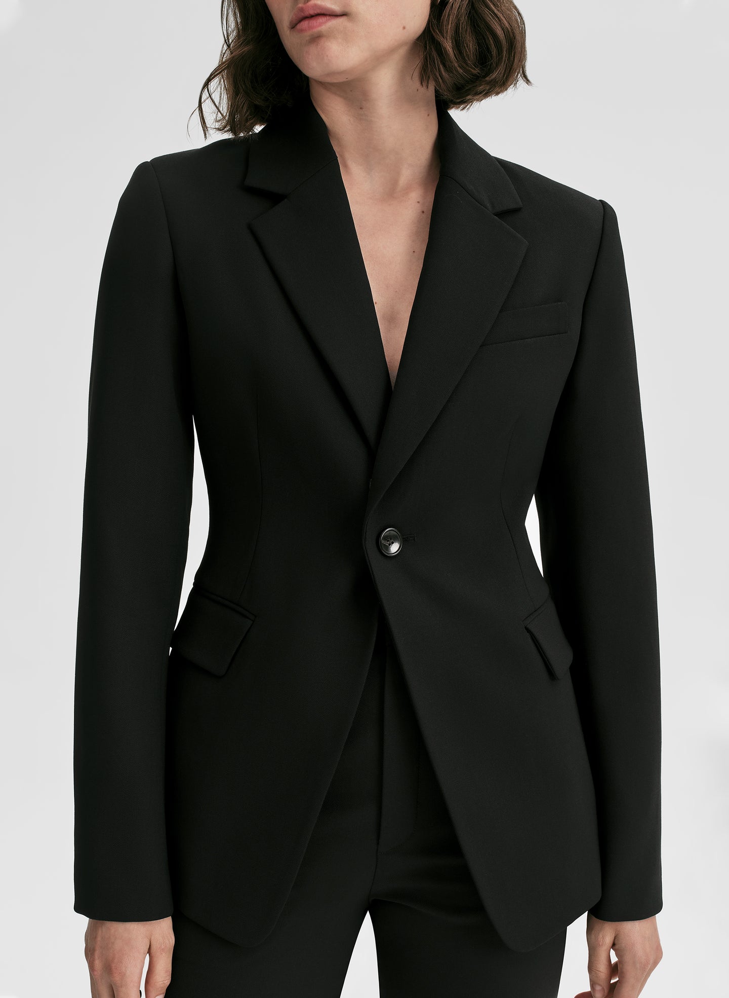 Black blazer worn by a person on a white background