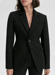 Black blazer worn by a person on a white background