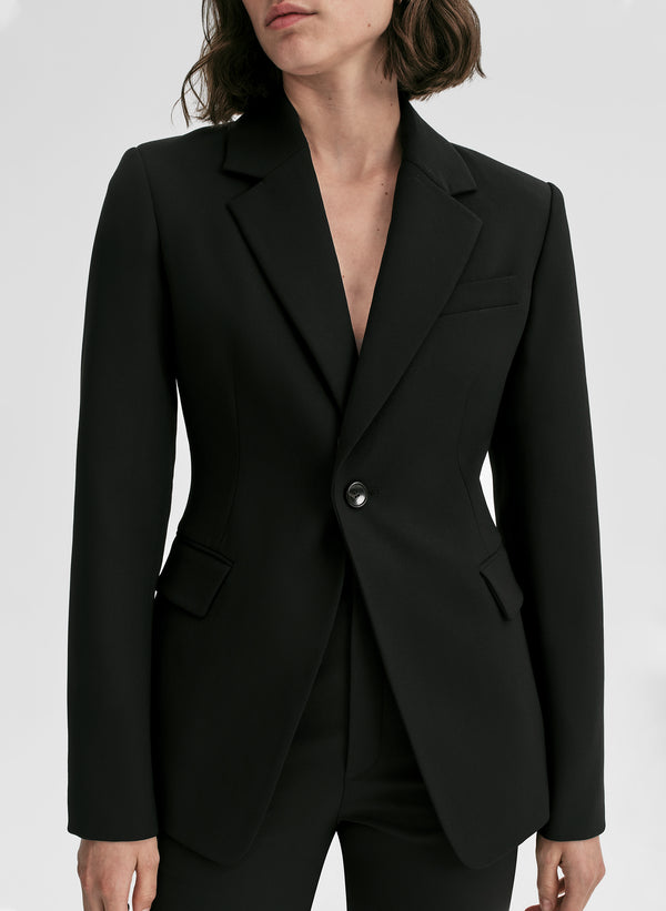 Black blazer worn by a person on a white background