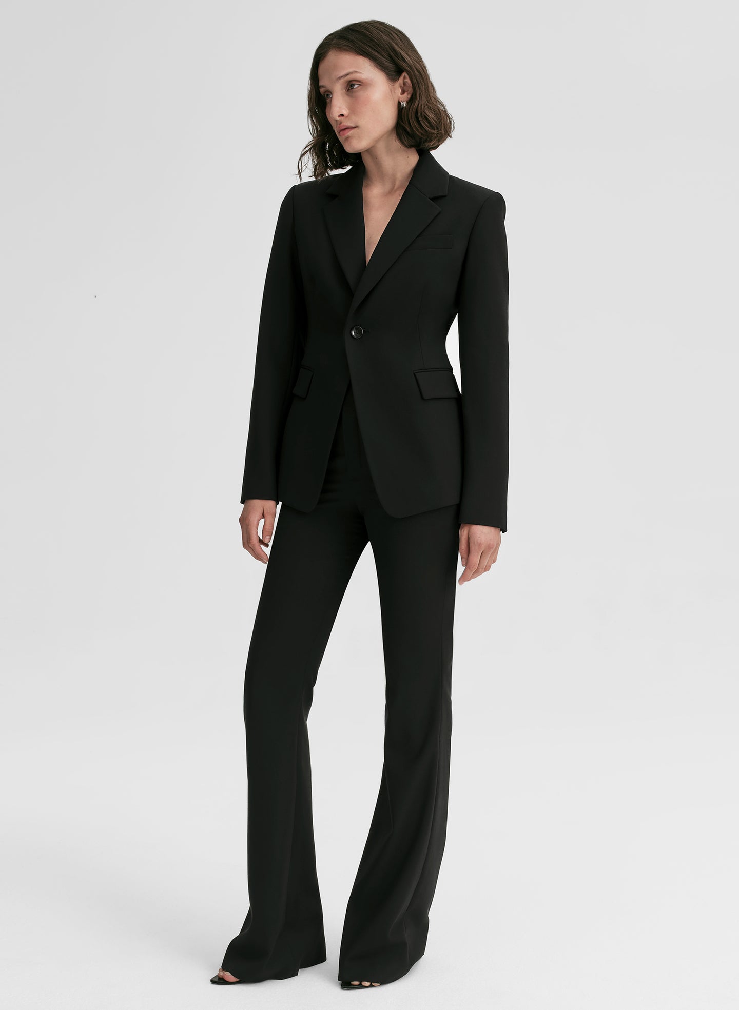 Woman wearing a black suit on a white background