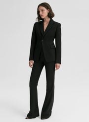 Woman wearing a black suit on a white background