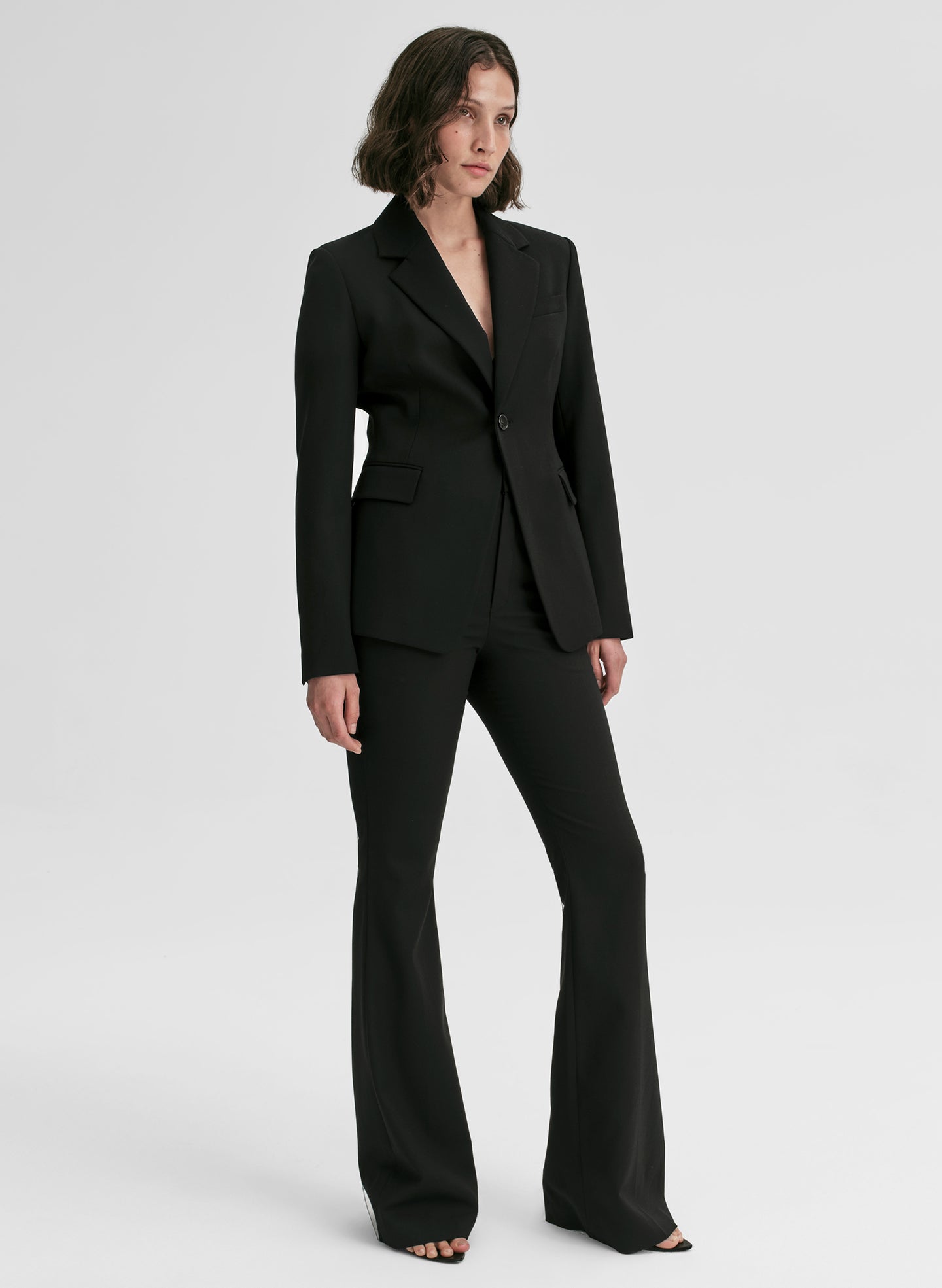 Woman wearing a black suit on a white background