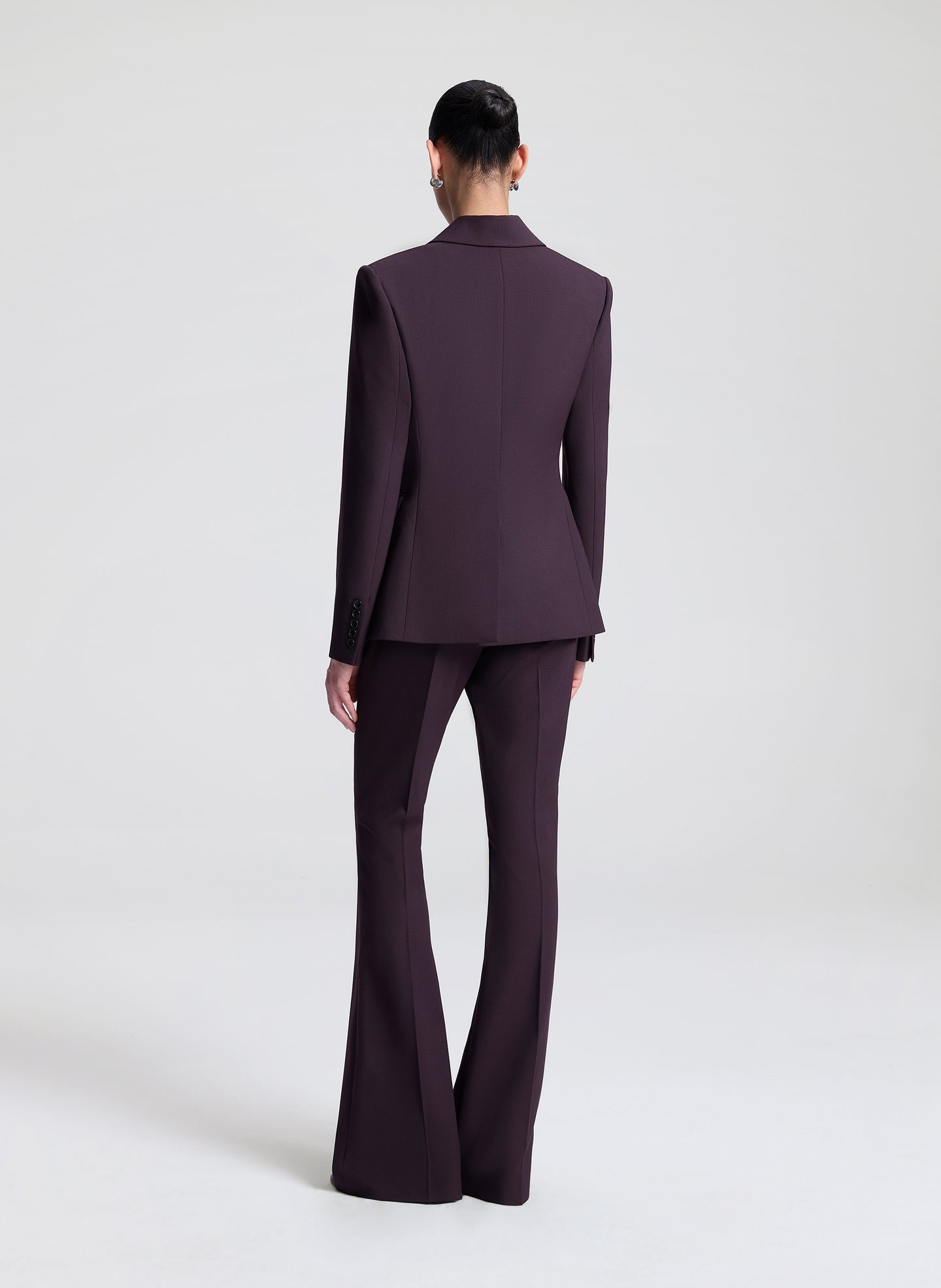 Person wearing a dark purple suit on a white background