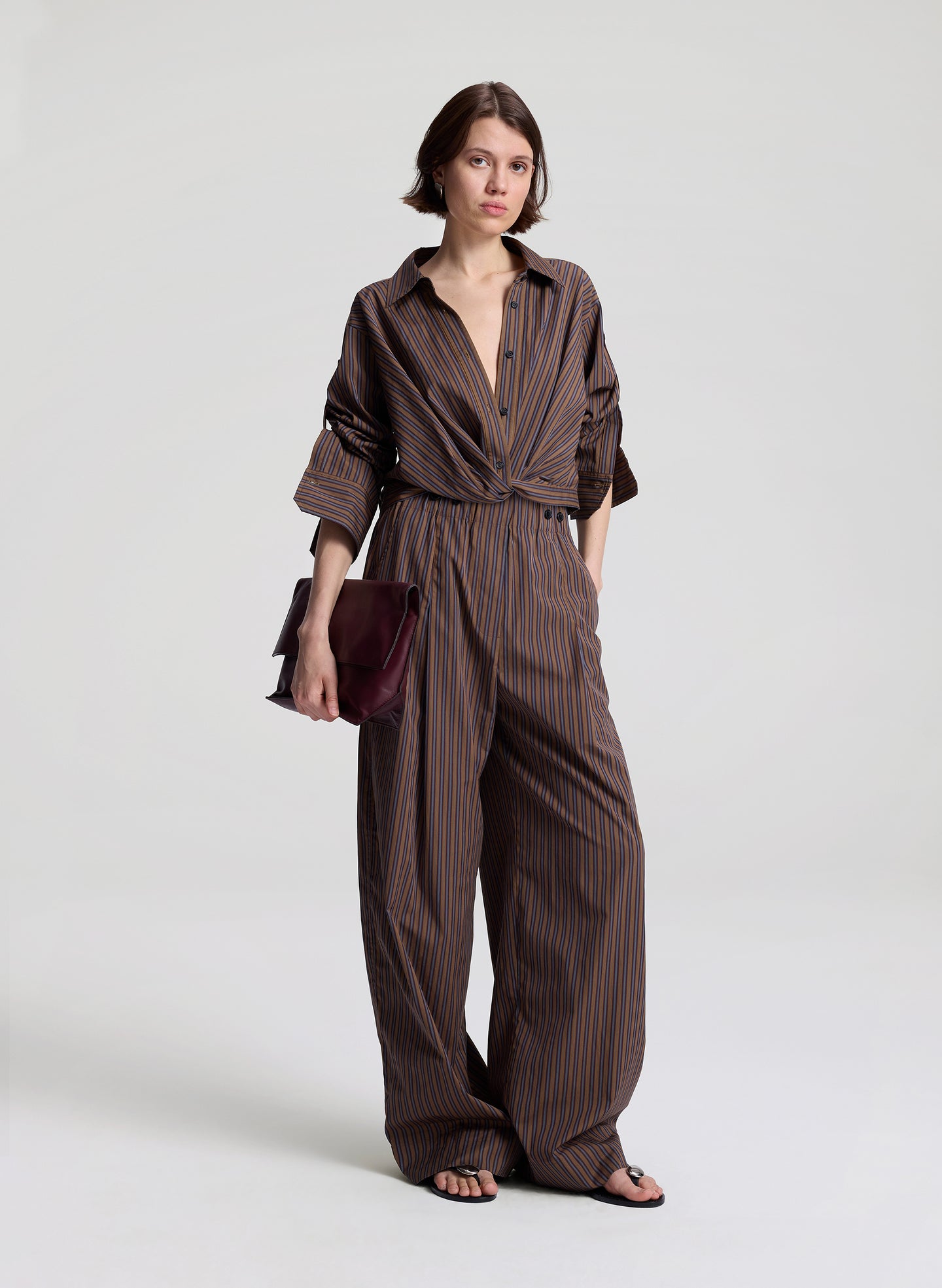 woman wearing brown button down shirt and matching set brown striped pants