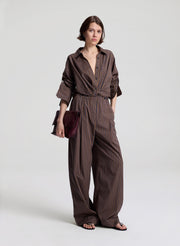 woman wearing brown button down shirt and matching set brown striped pants