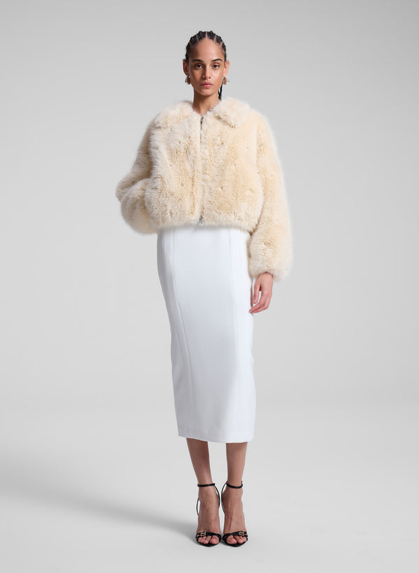 woman wearing cream faux fur jacket