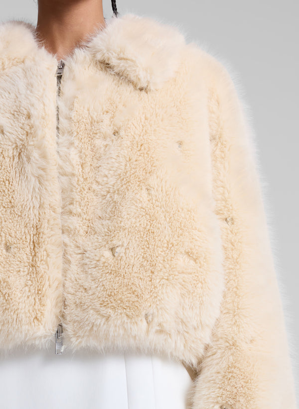 woman wearing cream faux fur jacket