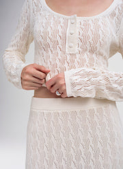 woman wearing cream knit top and skirt
