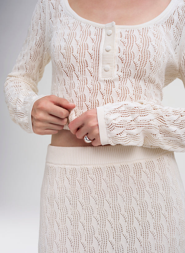woman wearing cream knit top and skirt