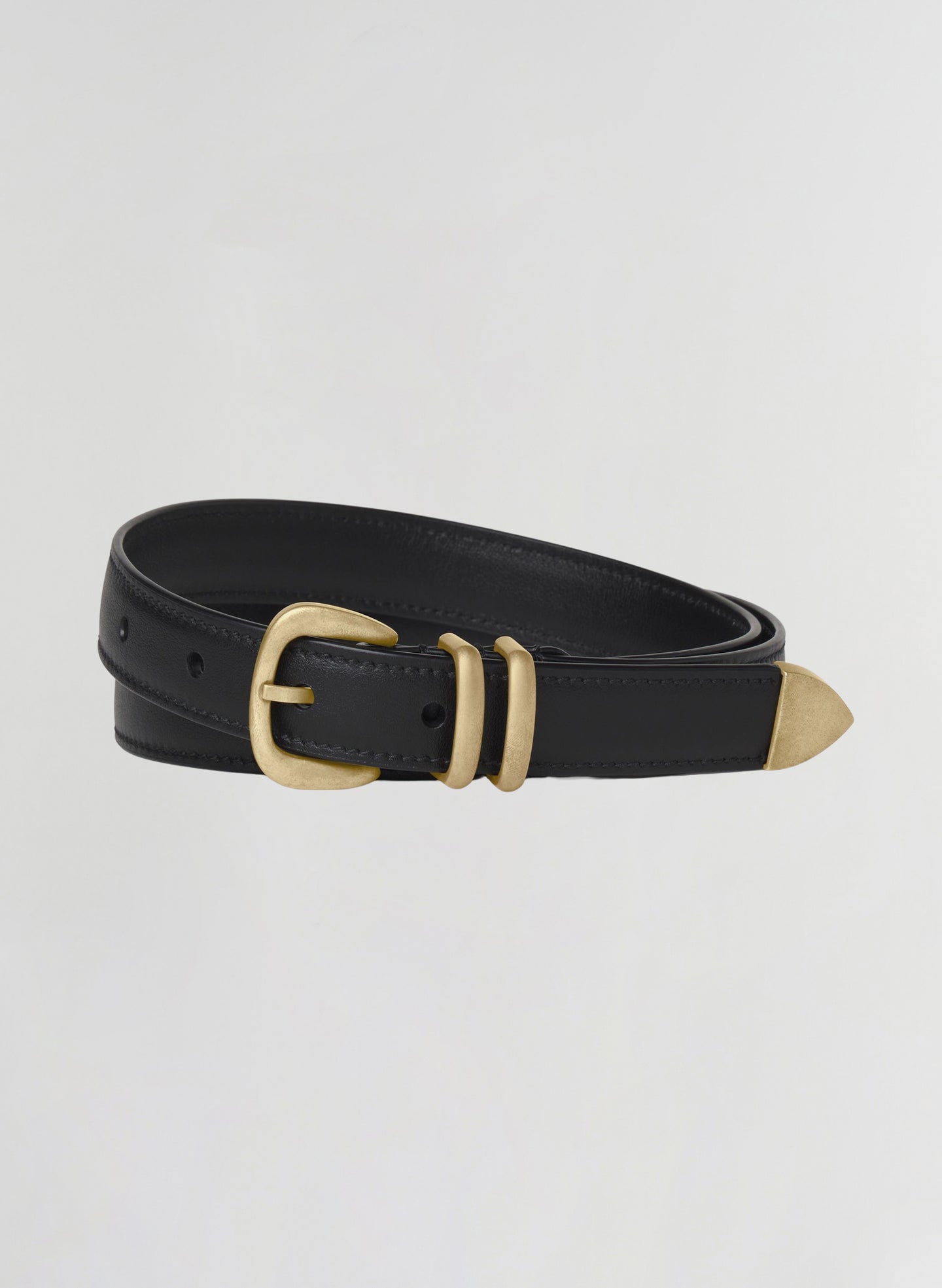A black leather belt with a gold-tone metal buckle, keeper, and tip, coiled on a light gray background.
