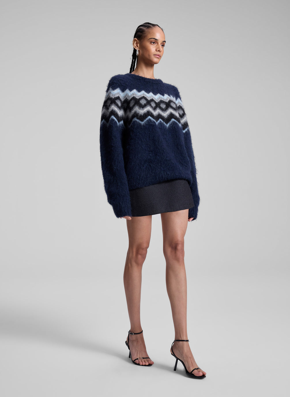 woman wearing navy fairisle sweater and grey mini skirt