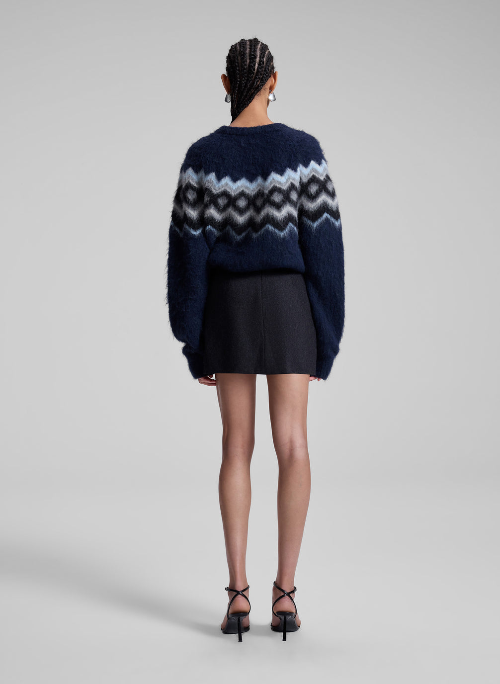 woman wearing navy blue fairisle sweater and grey mini skirt