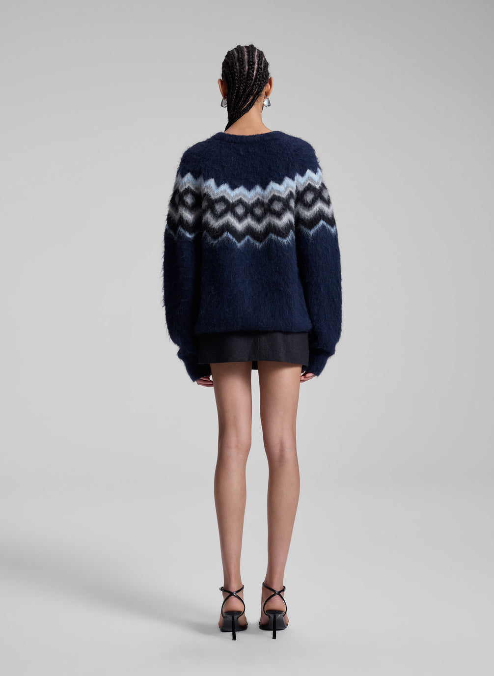 woman wearing navy fairisle sweater and grey mini skirt