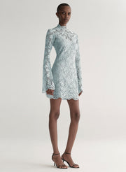 Woman wearing a light blue lace dress on a white background