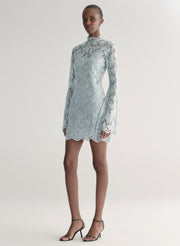 Woman wearing a light blue lace dress on a white background