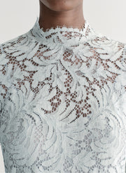 Woman wearing a light blue lace dress on a white background