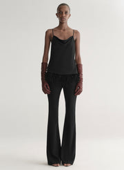 woman wearing black feather trim camisole and black pants
