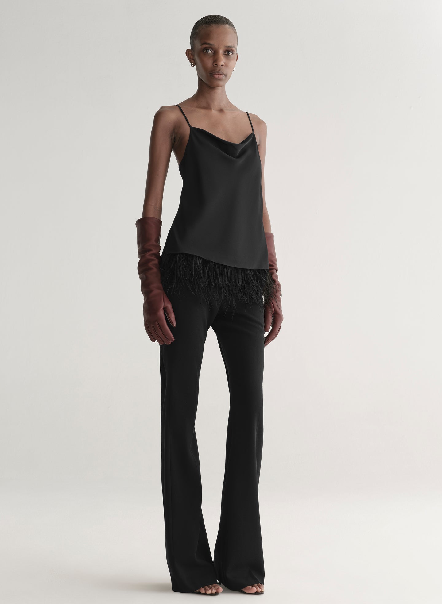 woman wearing black outfit and burgundy leather gloves