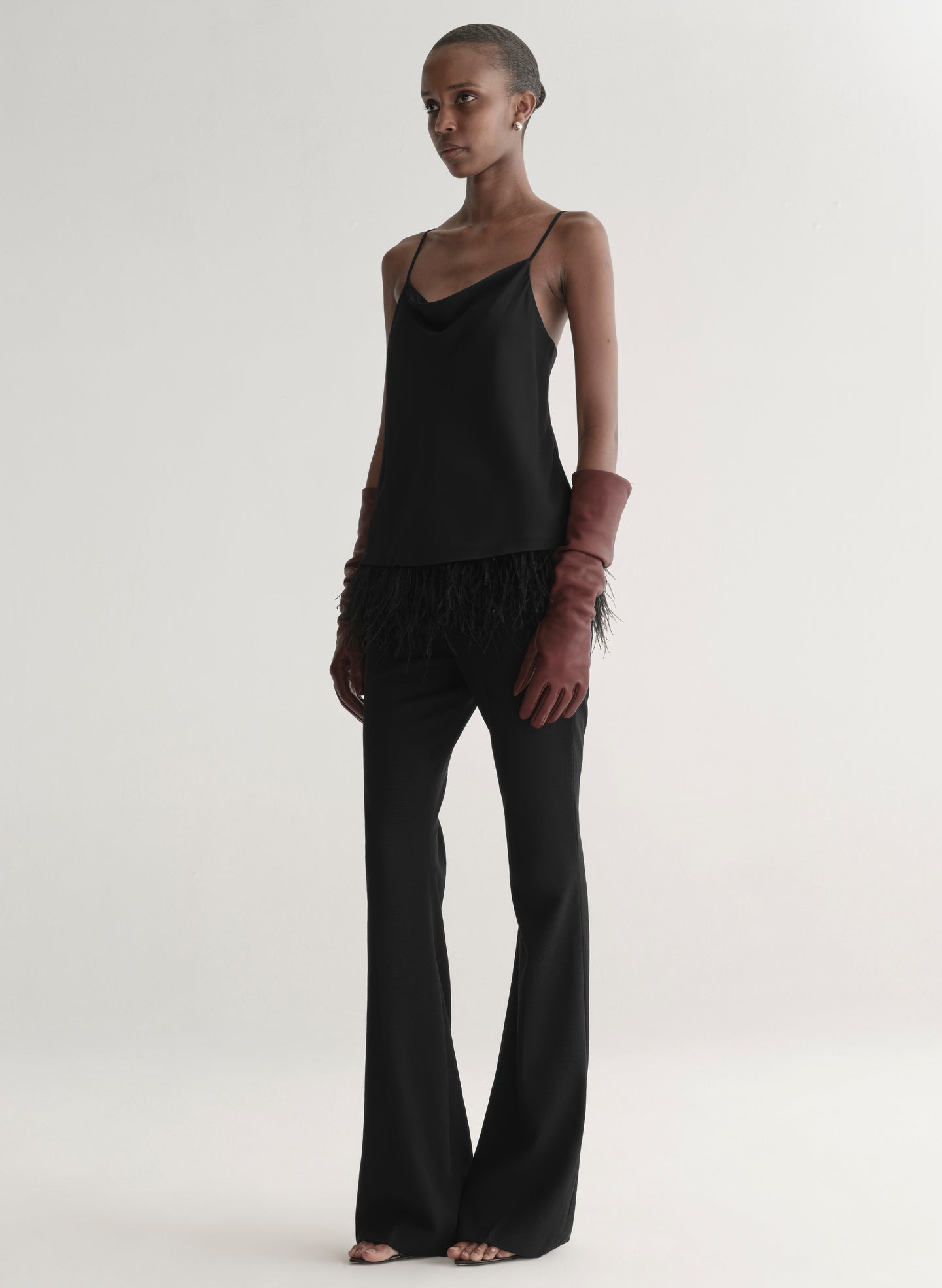 woman wearing black feather trim camisole and black pants
