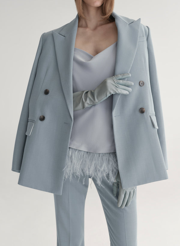 woman wearing light blue feather trim camisole and light blue pants