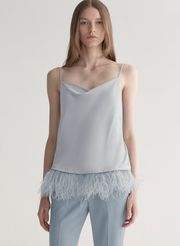 woman wearing light blue feather trim camisole and light blue pants