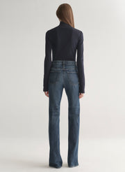 woman wearing dark blue turtleneck and blue denim jeans