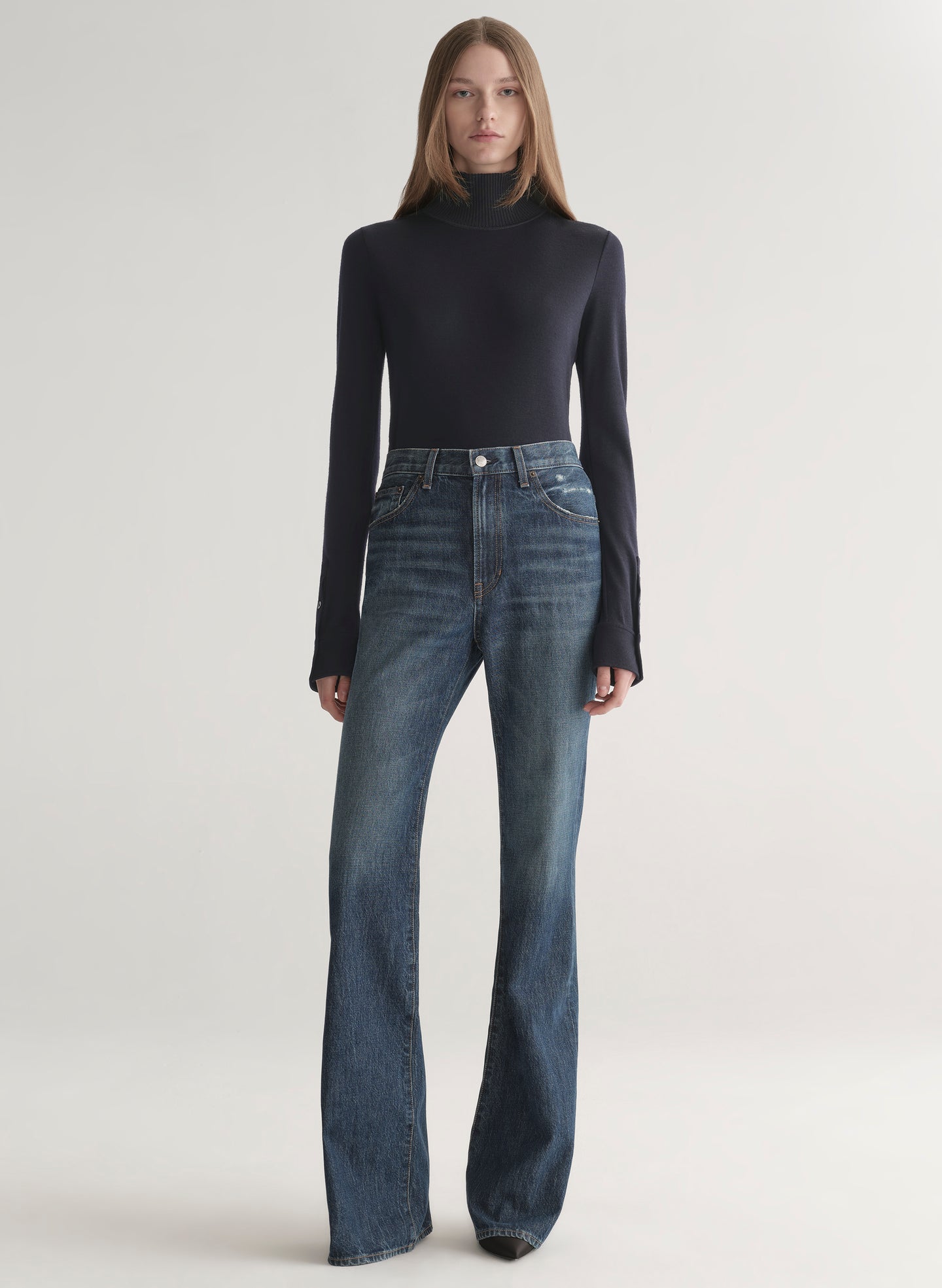 woman wearing dark blue turtleneck and blue denim jeans