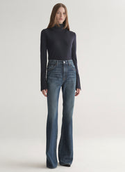 woman wearing dark blue turtleneck and blue denim jeans