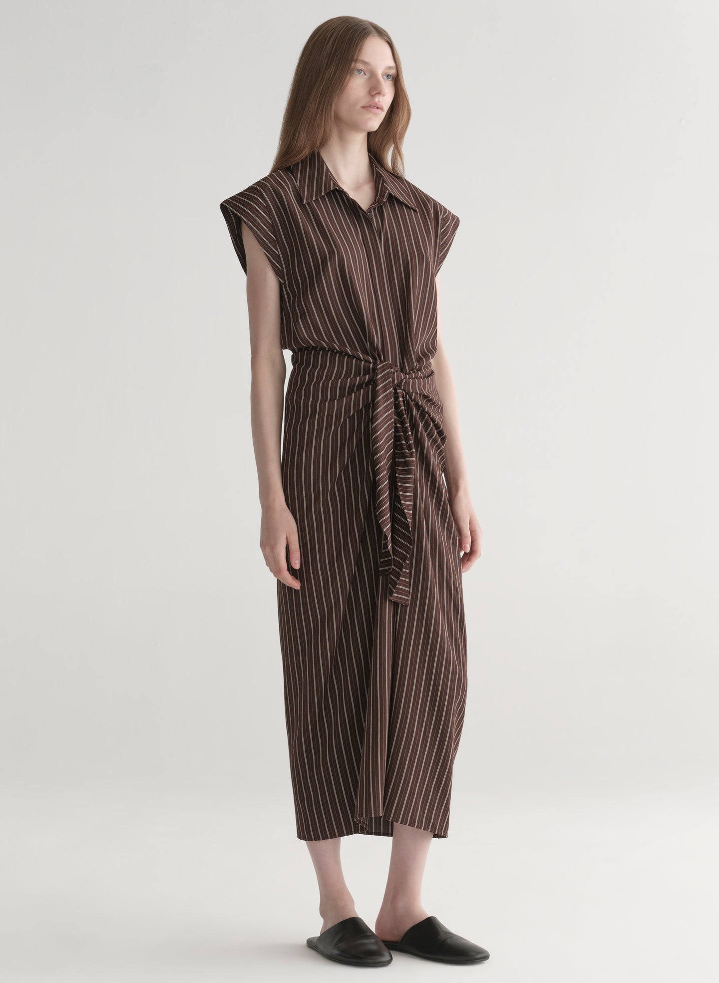 Woman wearing a brown striped dress on a white background