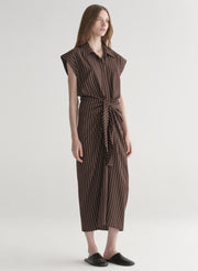 Woman wearing a brown striped dress on a white background