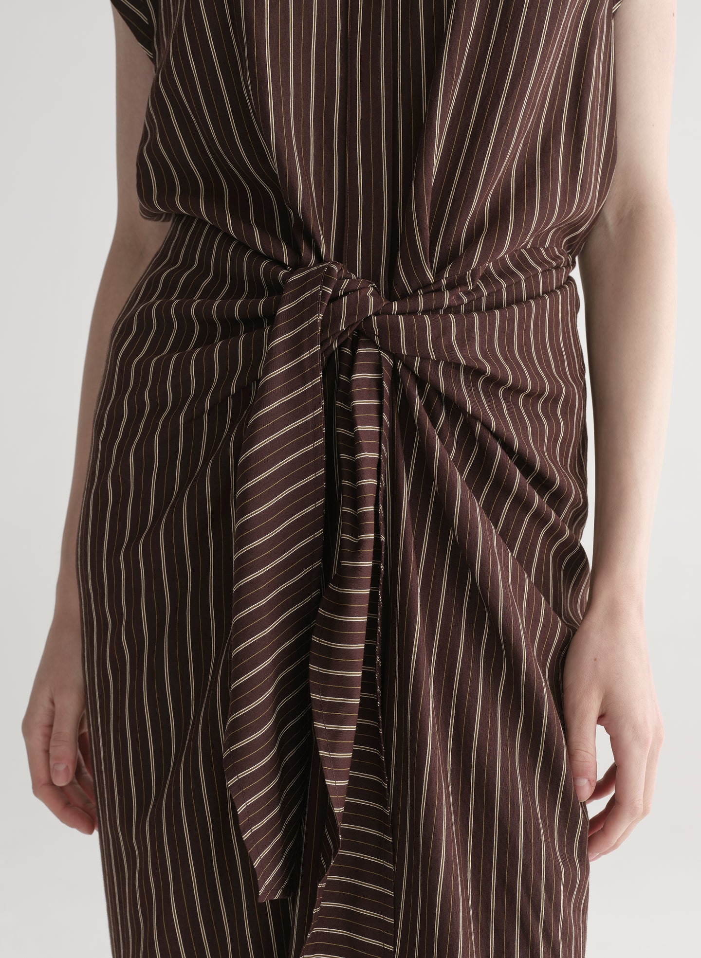 Woman wearing a brown striped dress on a white background