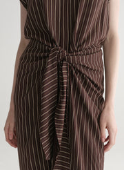 Woman wearing a brown striped dress on a white background