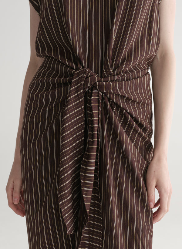 Woman wearing a brown striped dress on a white background