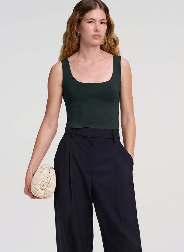 woman in green tank top and navy blue pants