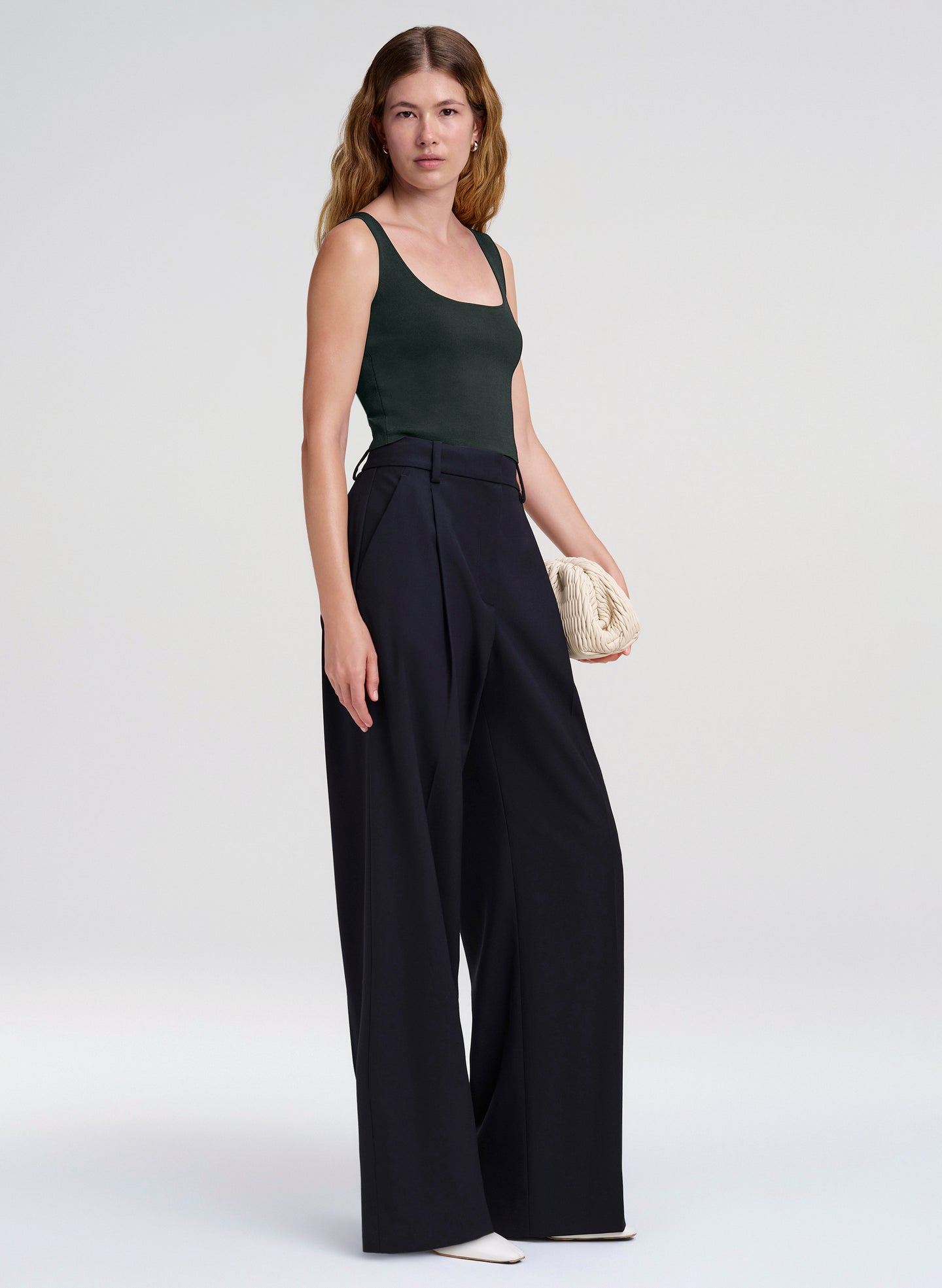 woman in green tank top and navy blue wide leg trousers