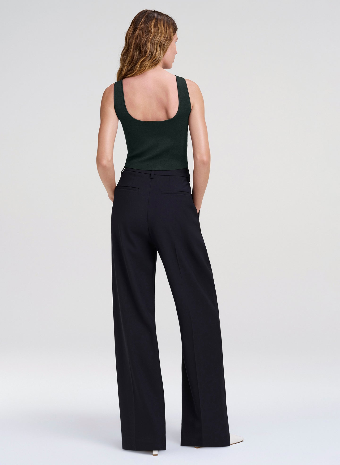 woman wearing green tank top and navy pants
