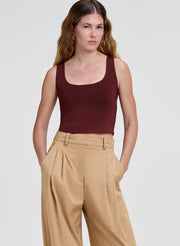 woman wearing maroon tank top and beige pants