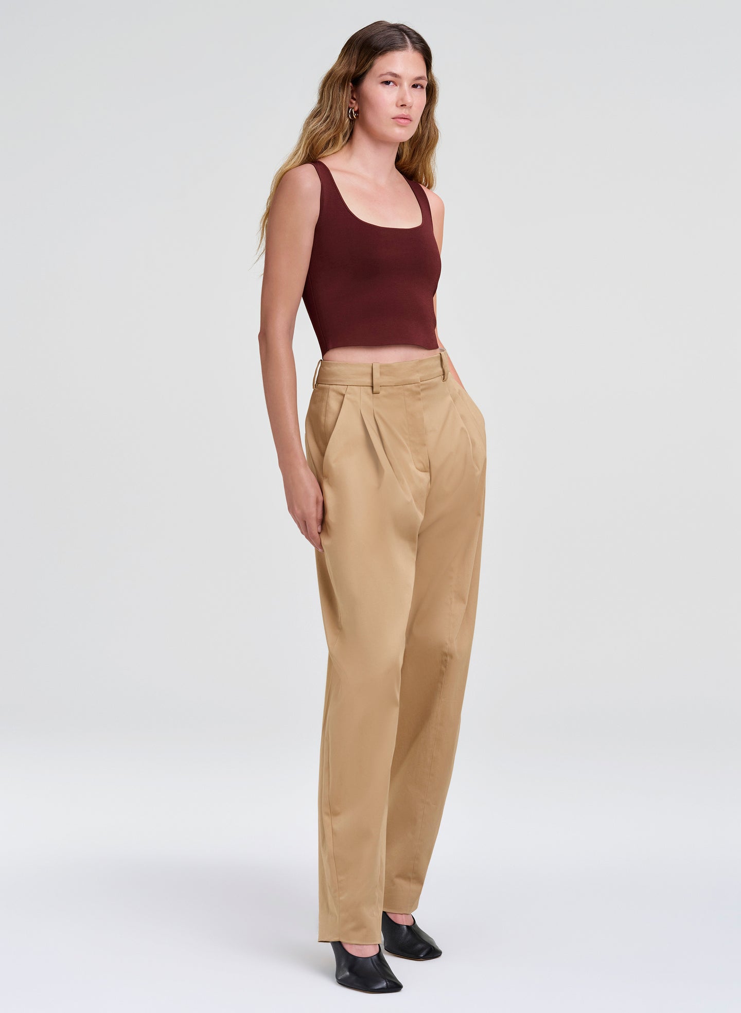 woman in maroon tank top and beige pants