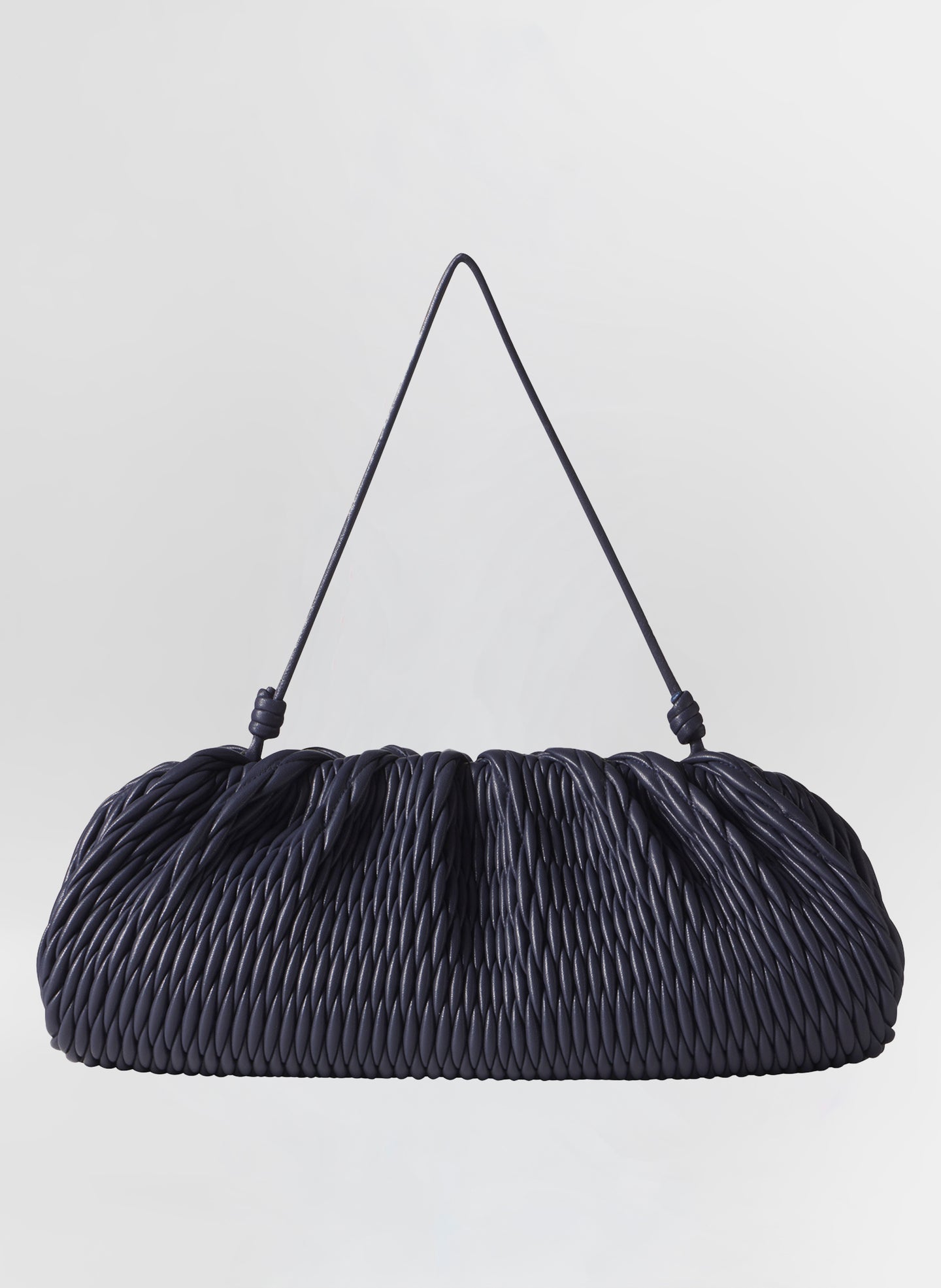 Navy blue quilted handbag with a strap on a light gray background