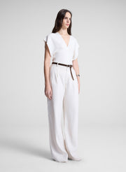 woman wearing white linen top and cream wide leg pant